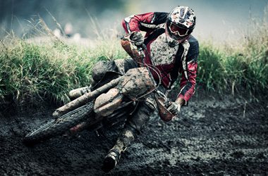 Person on dirt bike riding through mud